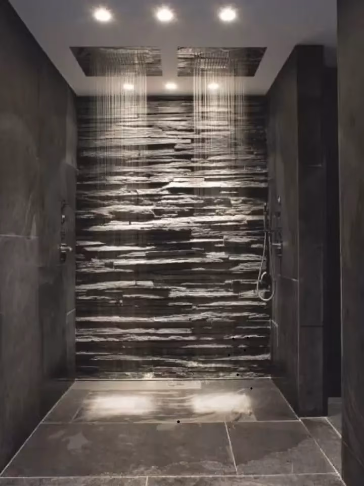 Grande douche double avec mur en ardoise, deux pommeaux et éclairage encastré au plafond