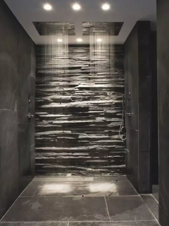 Grande douche double avec mur en ardoise, deux pommeaux et éclairage encastré au plafond