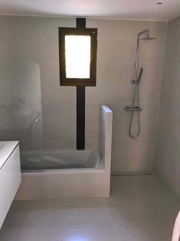 Douche avec paroi à cadre noir et carrelage clair