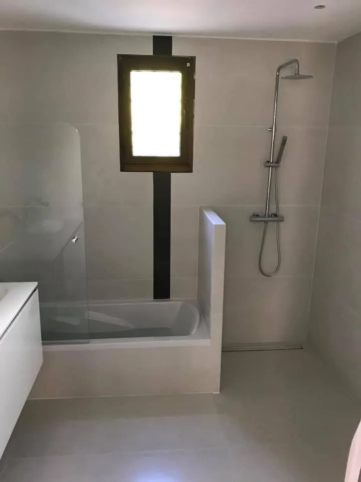 Douche avec paroi à cadre noir et carrelage clair