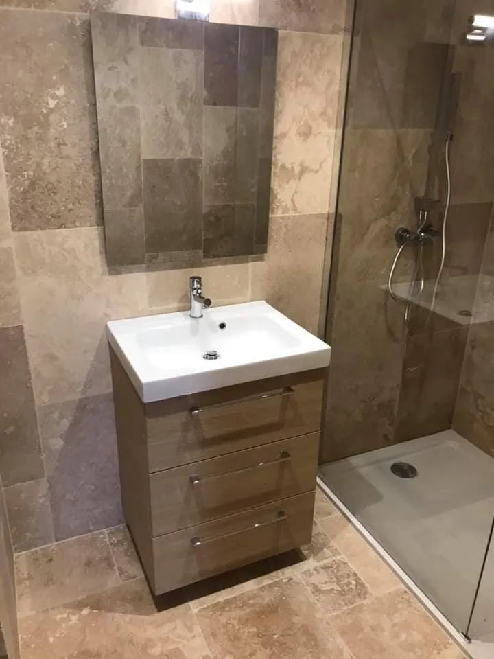 Meuble vasque en bois sur pied à côté d'une douche à l'italienne